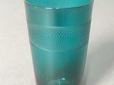 a blue glass cup sitting on a white surface