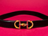a close up of a black belt with a gold buckle