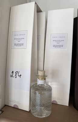 un flacon de parfum posé sur une étagère à côté de quelques livres