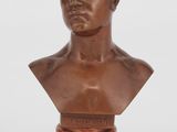 un buste en bronze représentant un jeune homme, posé sur un socle en marbre