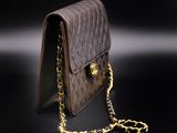 a close up of a brown purse on a black surface