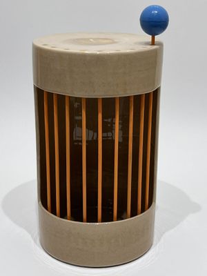 an image of a wooden and glass container with a blue ball on top