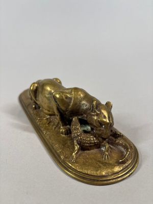 a gold plate with a frog sitting on top of it