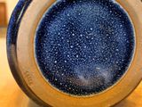 a close up of a blue and white vase on a wooden table