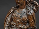a wooden statue of a woman holding a basket of flowers