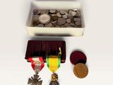 a small box of coins and a medal on a table