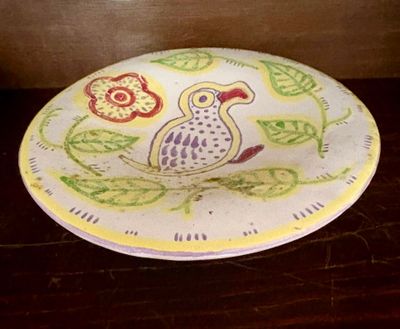 une assiette sur laquelle est peint un oiseau, posée sur une table