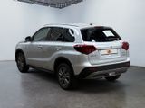 the rear end of a silver suv parked in a white room
