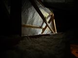 a window in the attic of a house with snow on the floor