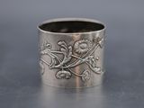 a close up of a silver ring with flowers and birds on it