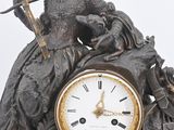 a statue of a woman holding a sword on top of a clock