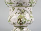a white vase with a green and white design on it