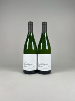 deux bouteilles de vin posées sur une table blanche