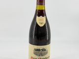a bottle of red wine sitting on top of a white table