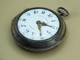 a silver pocket watch with a white face on a table