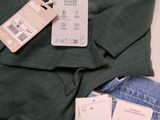 a green shirt and a pair of jeans with tags on them