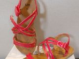 pink sandals with straps on top of a white box on a table