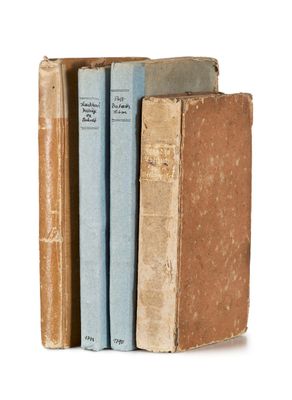 three books are stacked on top of each other on a white surface