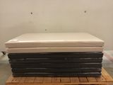 une pile de matelas posée sur une palette dans un entrepôt