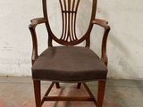 une chaise en bois avec une assise rembourrée marron
