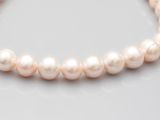 gros plan d'un collier de perles sur une surface blanche