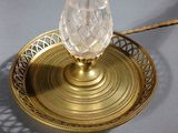 an antique brass table lamp with a glass shade on top of it