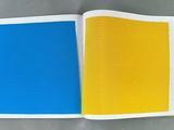 an open book with a yellow and blue cover sitting on top of a table