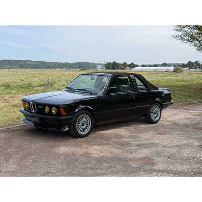 une photo d'une voiture noire garée sur le bord de la route