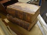 two old books stacked on top of each other on a table