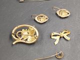 a lot of gold brooches and pins on a table