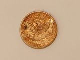 a close up of a gold coin on a white surface