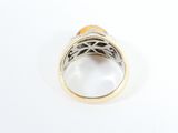 a close up of a ring with an orange stone in it