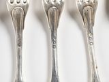 four forks that are sitting next to each other on a table