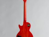 a red electric guitar hanging from a white wall
