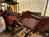une photo représentant un tracteur et une chargeuse dans un garage
