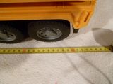 un camion-jouet jaune à côté d'un mètre ruban