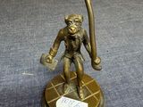 a bronze statue of a monkey holding a baseball bat
