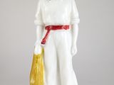 une figurine représentant un homme tenant un sac jaune à la main