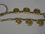 a close up of a gold chain with a ring on it