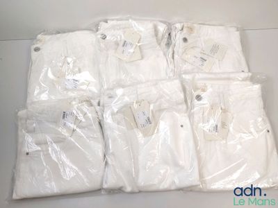 Plusieurs sacs contenant des chemises blanches sont posés sur une table