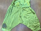 une photo d'un pantalon vert posé sur un parquet