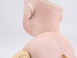 a small doll with a bandage around it ' s neck