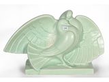 une statue représentant un oiseau perché sur une table