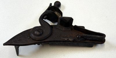 un vieux pistolet posé sur une surface blanche