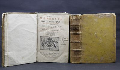 two old books sitting on top of each other on a table