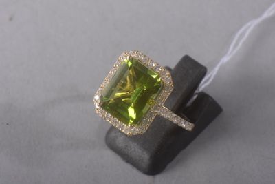 an image of a ring with a green stone surrounded by diamonds