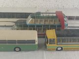 six petits bus en jouet posés sur une table