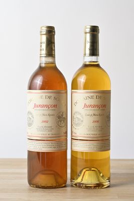 deux bouteilles de vin posées sur une table l'une à côté de l'autre