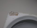 a close up of a white toilet with a brown sticker on it