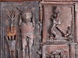 a wooden panel with carvings of people and animals on it